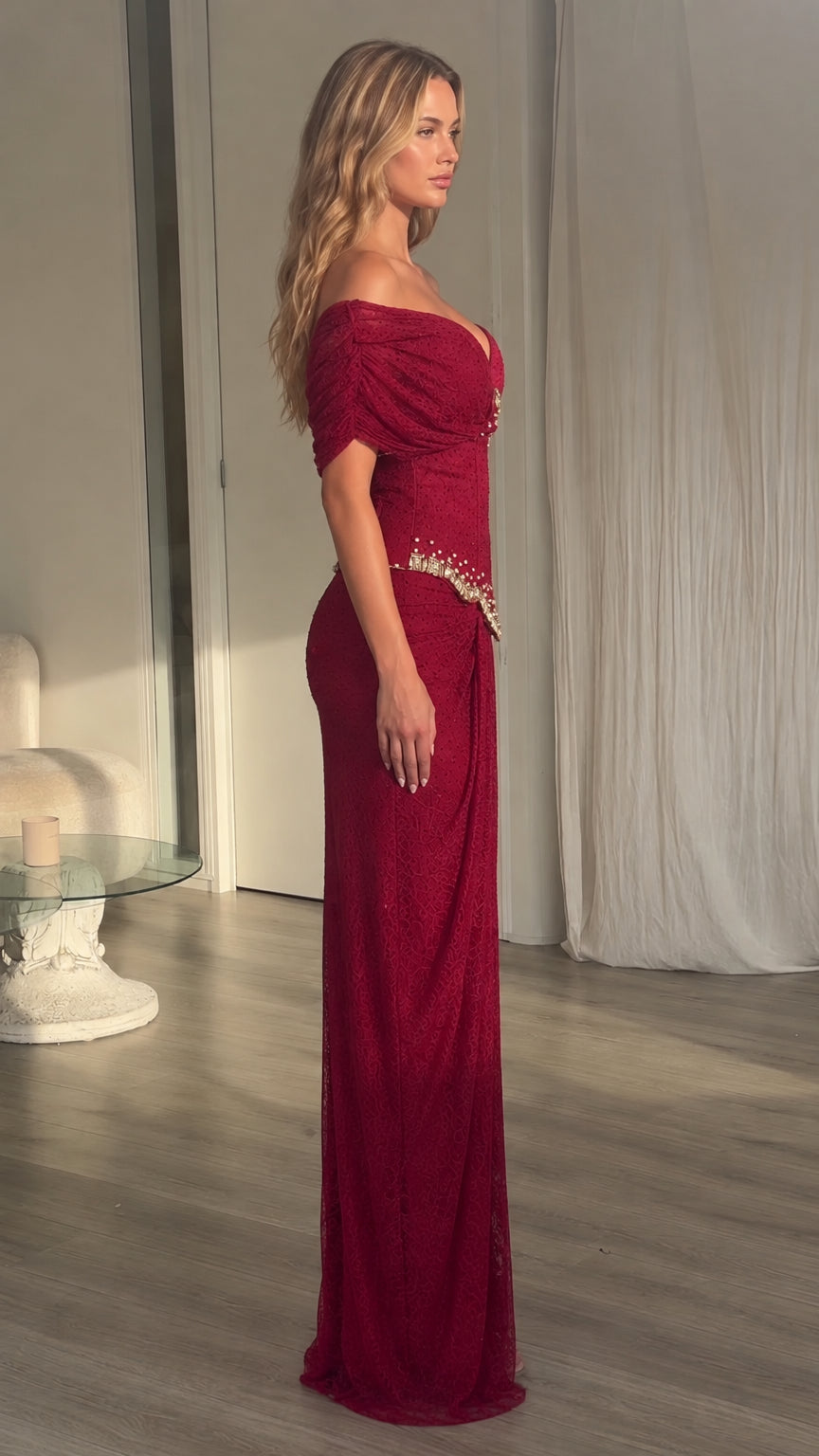 Side profile view of model wearing burgundy off-shoulder formal evening gown