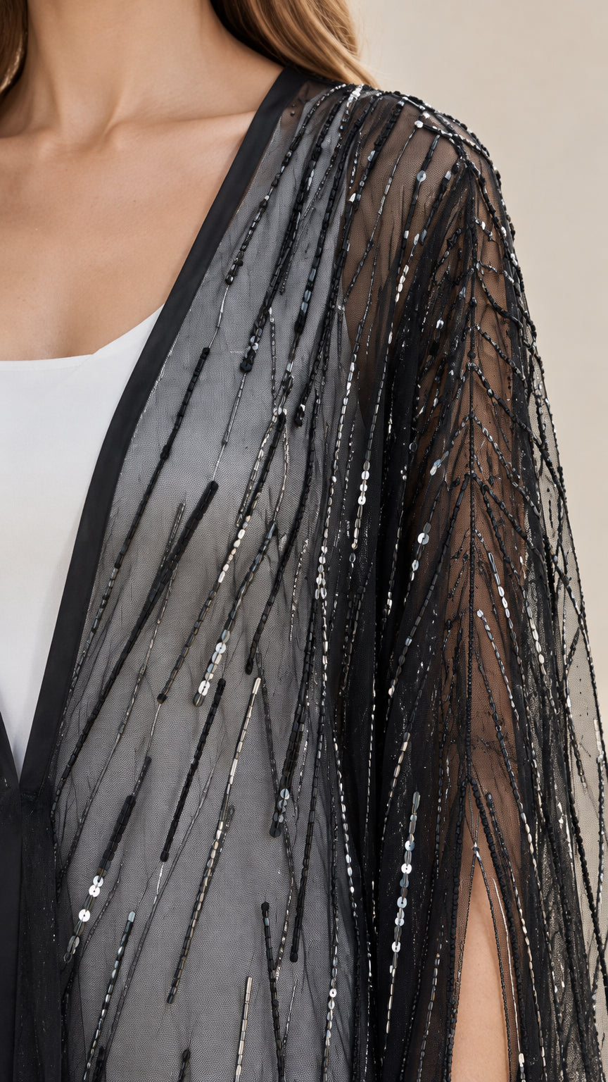 Close-up detail of sheer black mesh and shimmering linear sequin embroidery