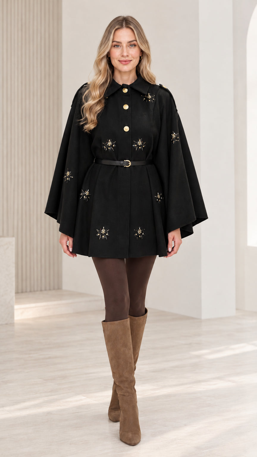 Front view of woman wearing black embellished button-front belted cape coat