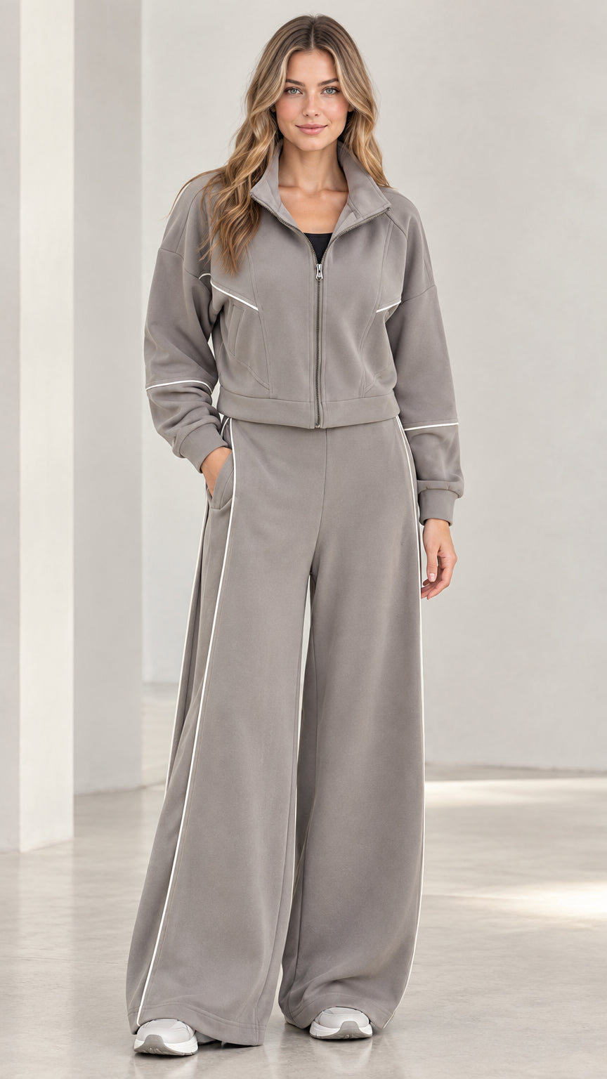 Front full view of woman wearing grey contrast piping zip-up jacket and wide leg tracksuit set