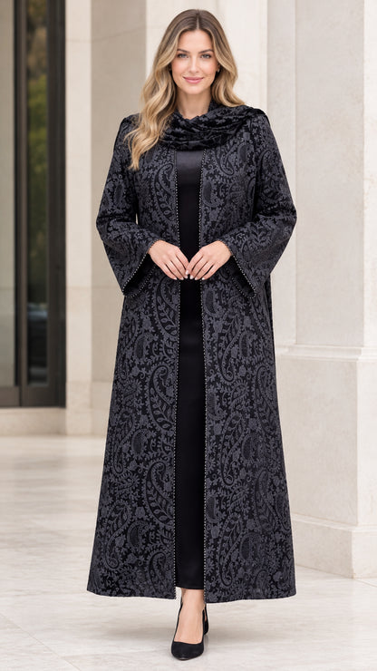 Front full-length view of woman wearing black paisley jacquard maxi duster coat with matching draped scarf