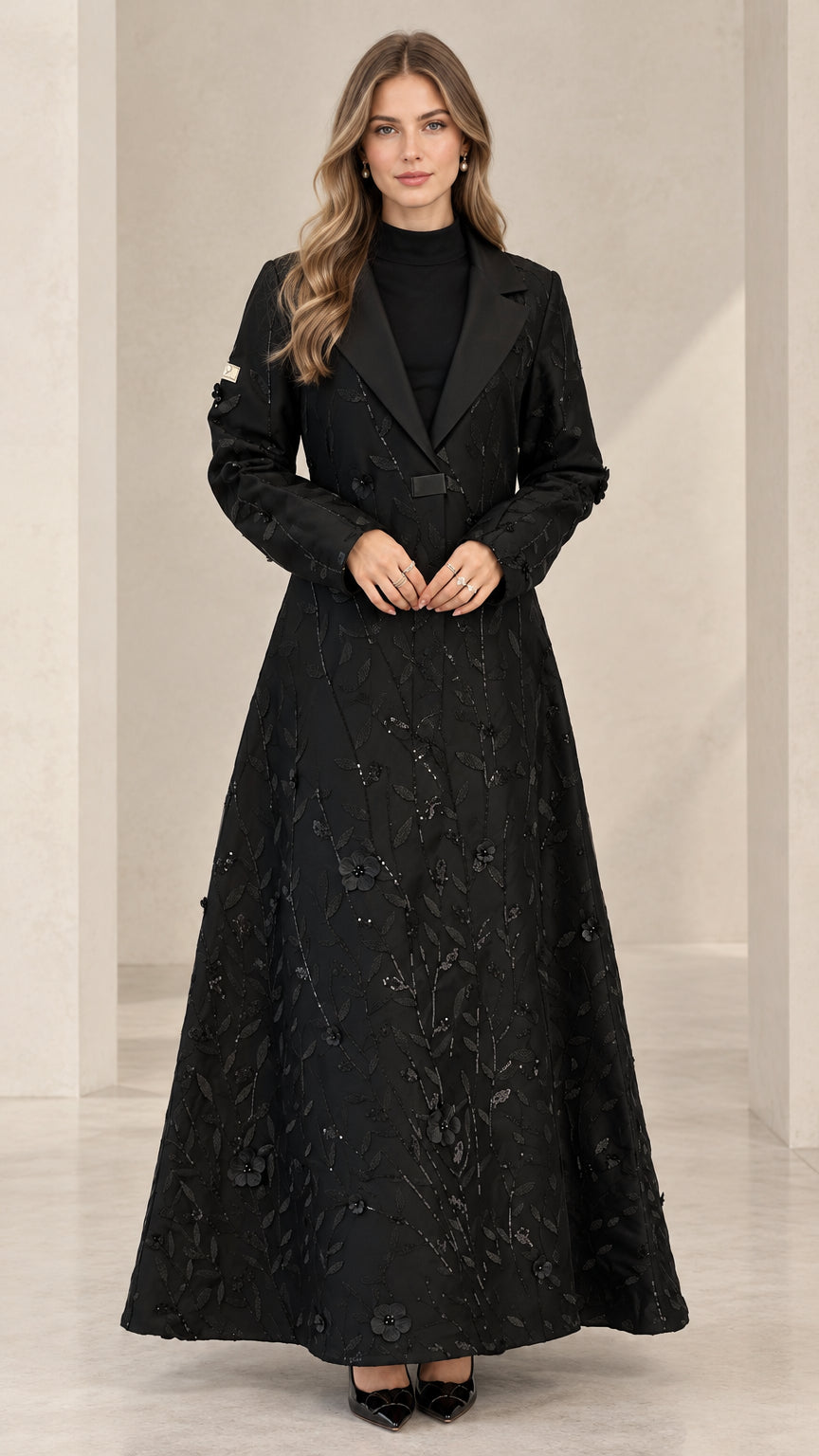 Front full-length view of woman wearing black floral sequin maxi evening coat with satin lapel