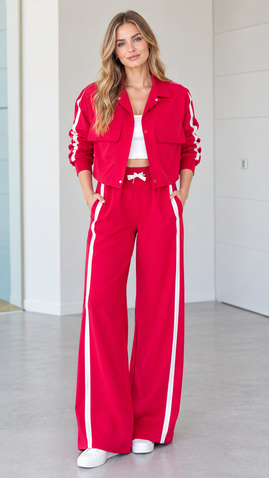 Front full view of woman wearing red 2-piece side stripe cropped jacket and wide-leg track pants set