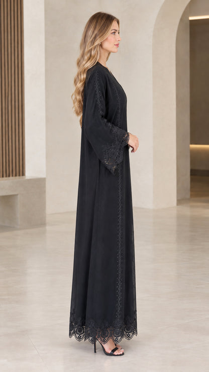 Side profile of woman wearing black flowy lace trim abaya dress