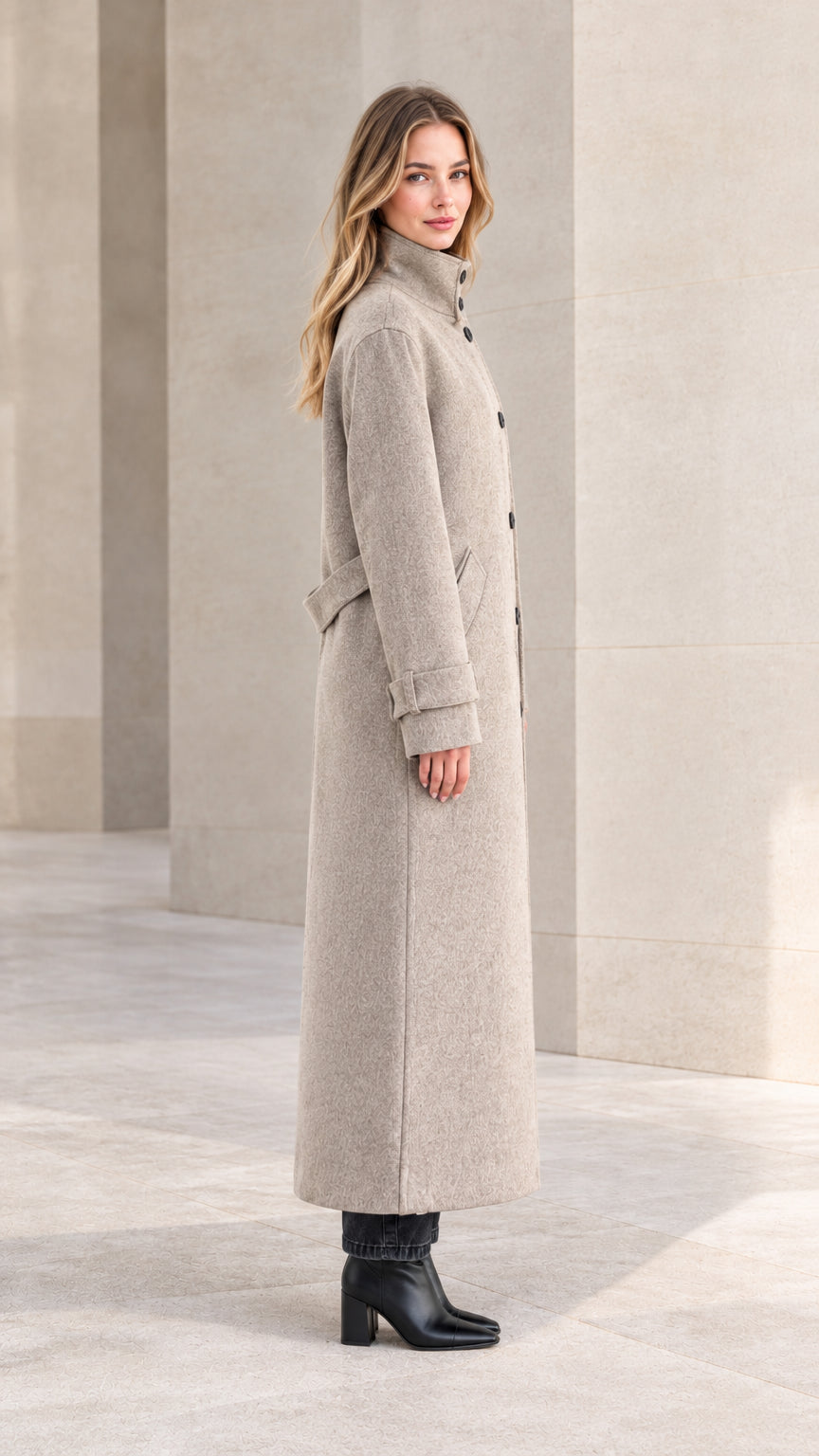 Side profile of woman in heather grey long overcoat showing sleek tailored fit