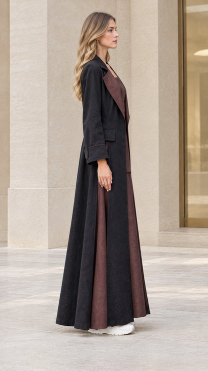 Side profile view of woman wearing dramatic floor-length black duster coat