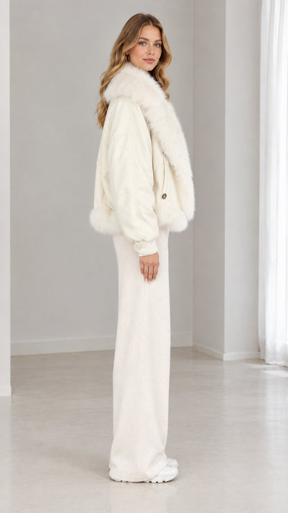 Side profile view of woman wearing cream faux-fur trim bomber jacket