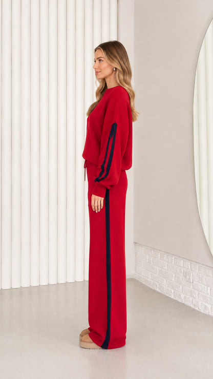 Side profile of model wearing red knit sweater and wide leg lounge pants
