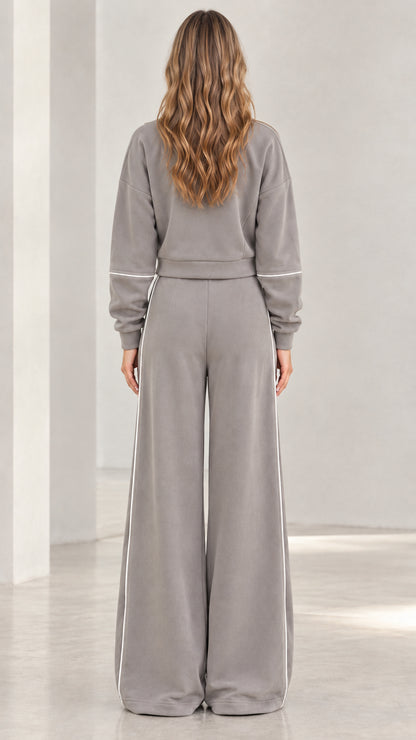 Back view of woman wearing grey two-piece zip jacket and wide leg pants set