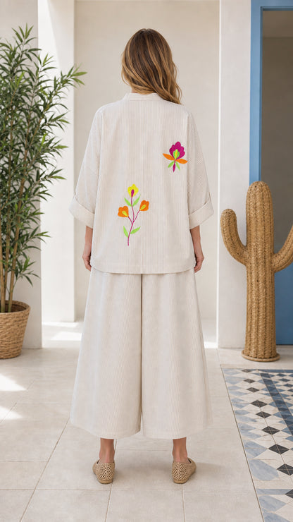 Back view of woman wearing beige embroidered two-piece set