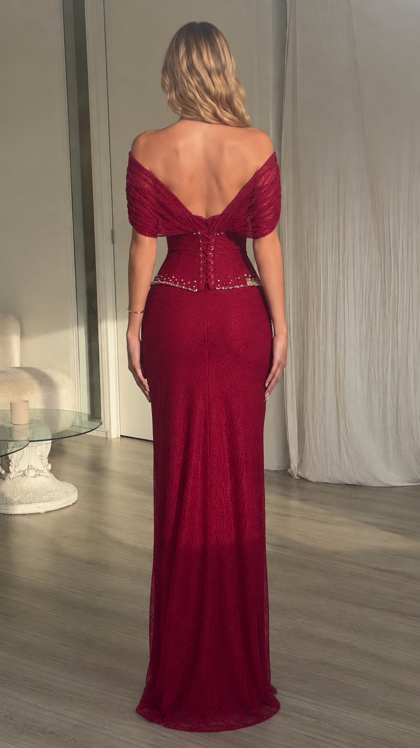 Back view of model wearing burgundy off-the-shoulder draped evening dress