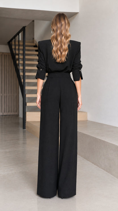 Back full view of woman wearing black structured-shoulder wide-leg jumpsuit