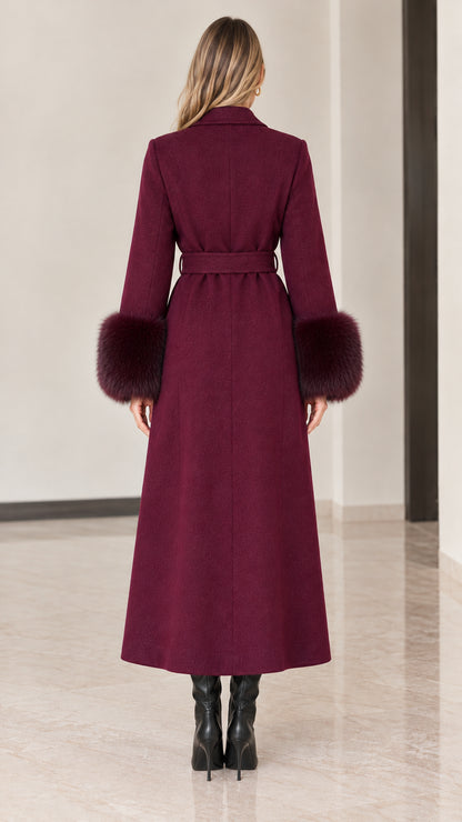 Back view of model in full-length burgundy overcoat showing tailored seams and belt