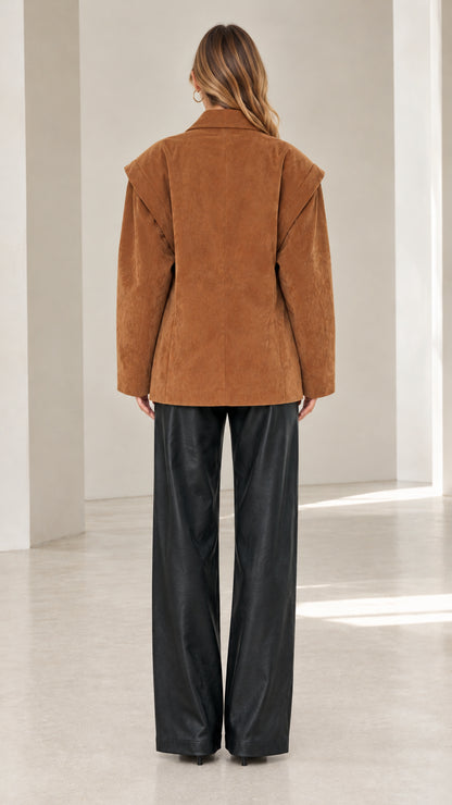 Back view of model in camel faux suede blazer highlighting shoulder overlay construction