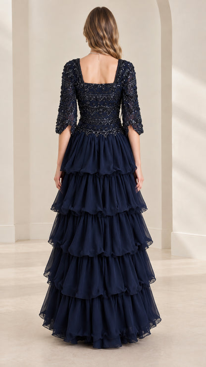 Back view of navy blue beaded square neck evening gown with cascading ruffles