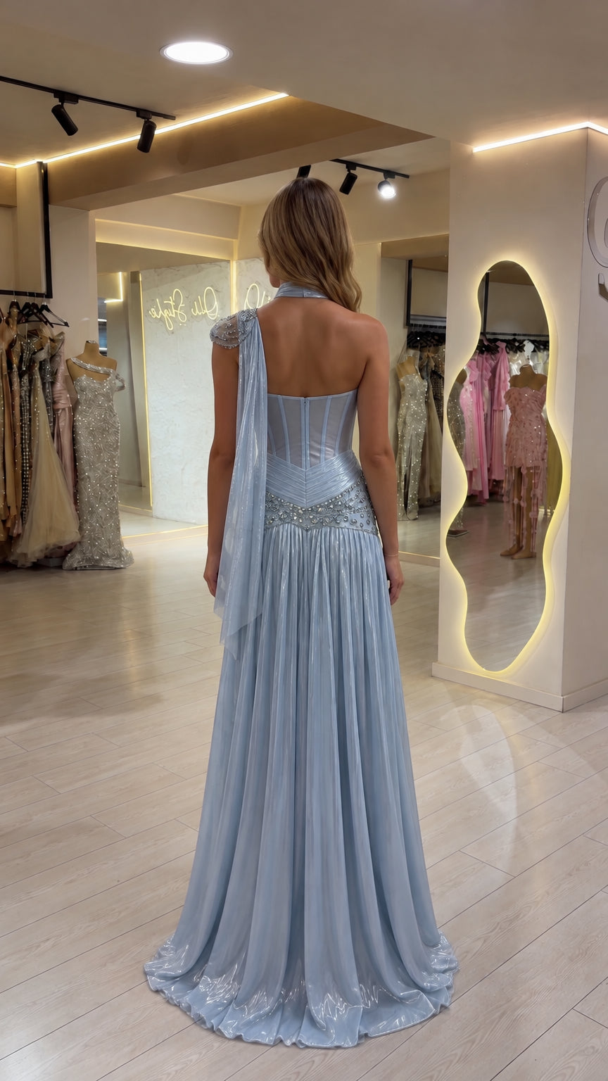 Back view of woman wearing Ice Blue one-shoulder evening gown showing corset back and cape drape