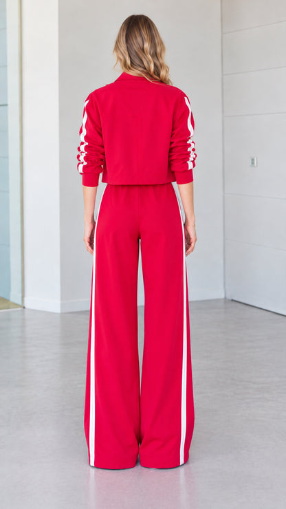 Back view of woman wearing red cropped jacket and wide-leg tracksuit pants
