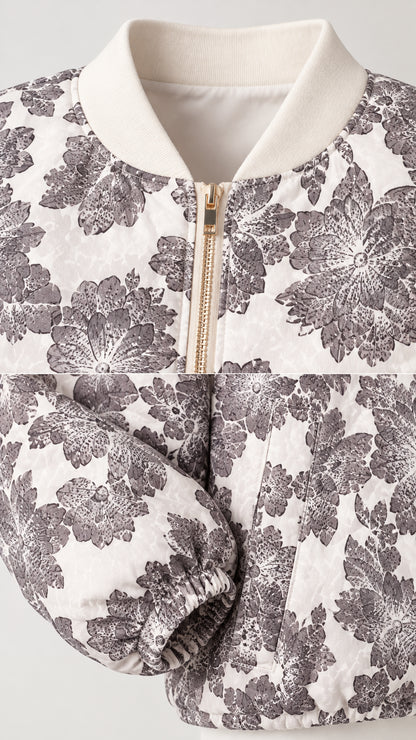 Close-up detail of ribbed collar, front metallic zipper, and floral fabric cuff