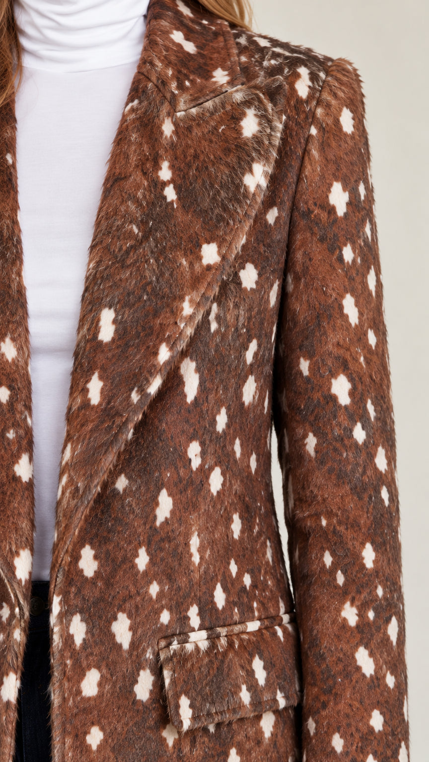 Close-up detail of notched lapel and textured spotted faux-fur fabric on brown coat