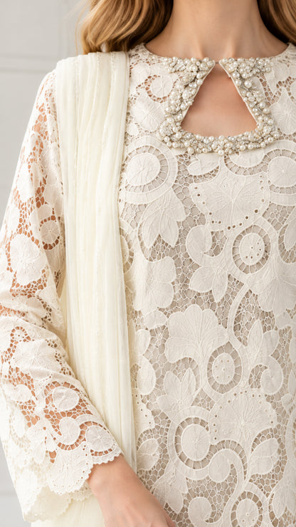 Close-up of Ivory tunic showing pearl-beaded keyhole neckline and textured floral lace