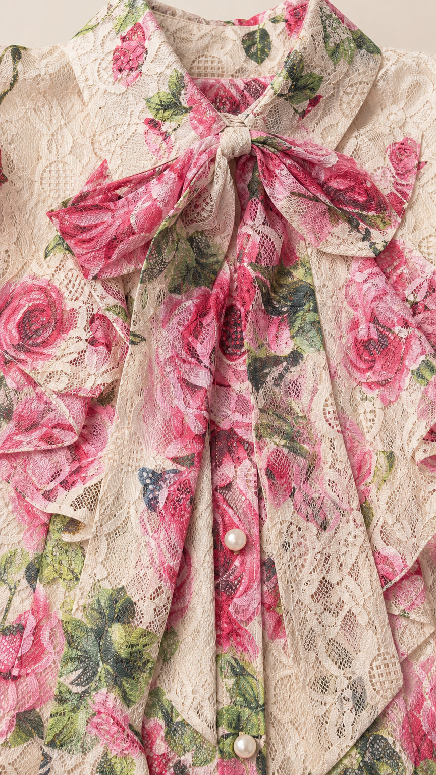 Close-up of the tie-neck bow, lace texture, and faux-pearl buttons on the top