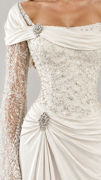Close-up detail of crystal brooches, ruching, and beaded lace sleeves