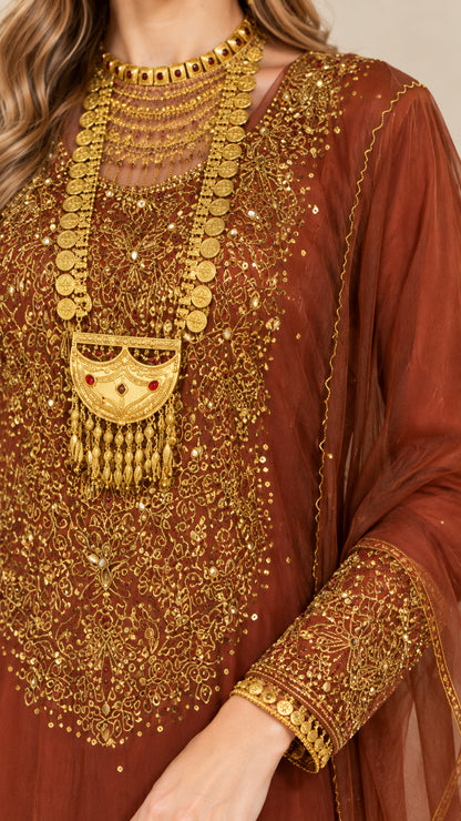 Close-up of intricate gold embroidery on bodice and cuff of rust brown gown