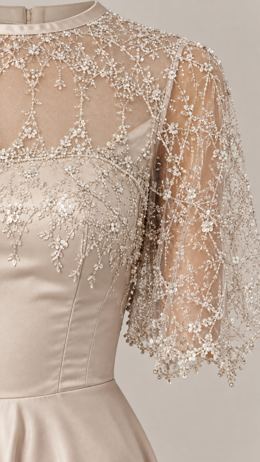 Close-up detail of beaded and embroidered sheer illusion bodice and cape sleeves