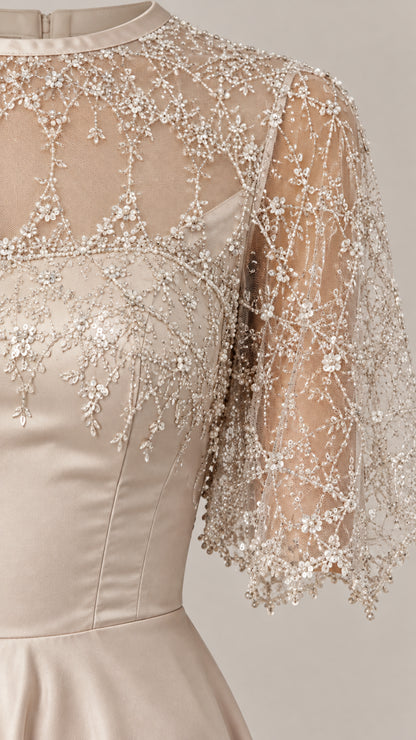 Close-up detail of beaded and embroidered sheer illusion bodice and cape sleeves