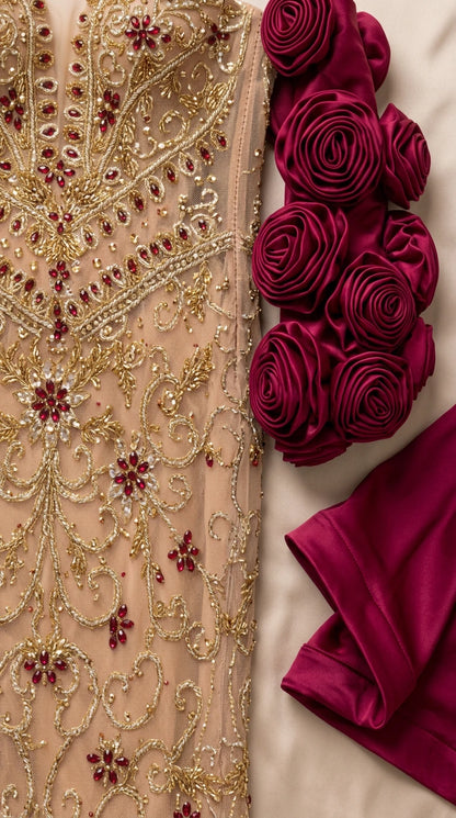 Close-up detail of gold and crimson beadwork and satin 3D rosettes