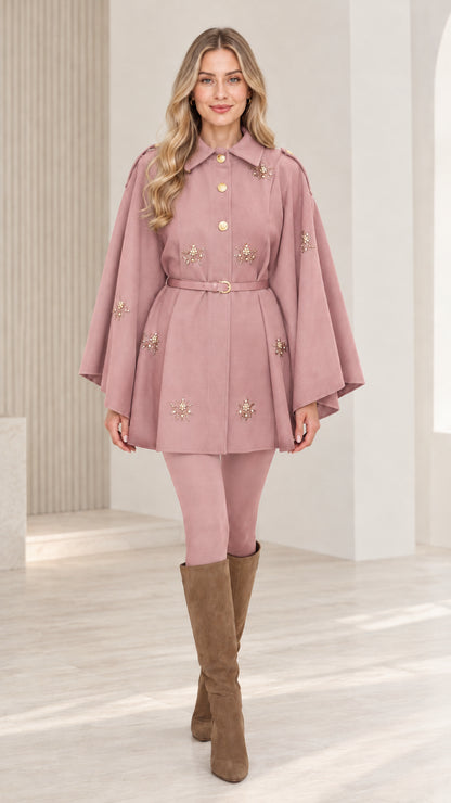 Front view of woman wearing dusty rose embellished button-front belted cape coat
