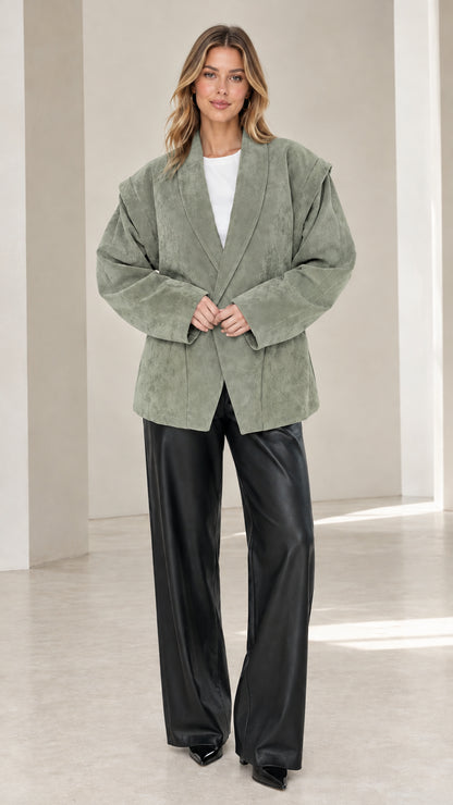 Front view of model wearing sage green faux suede oversized tailored blazer