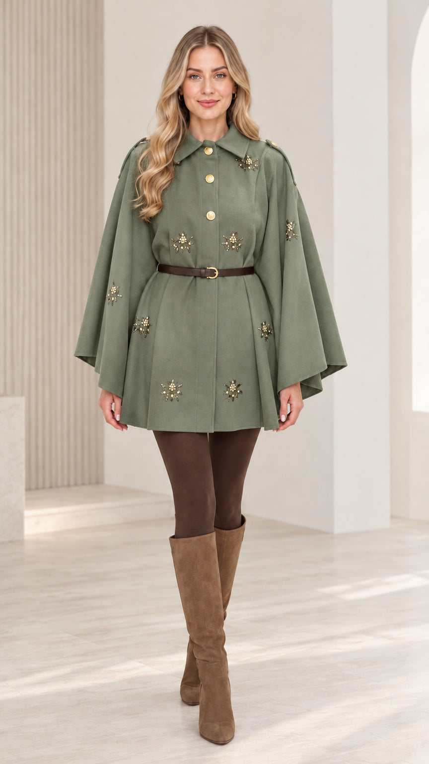 Front view of woman wearing sage green embellished button-front belted cape coat