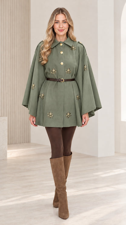 Front view of woman wearing sage green embellished button-front belted cape coat