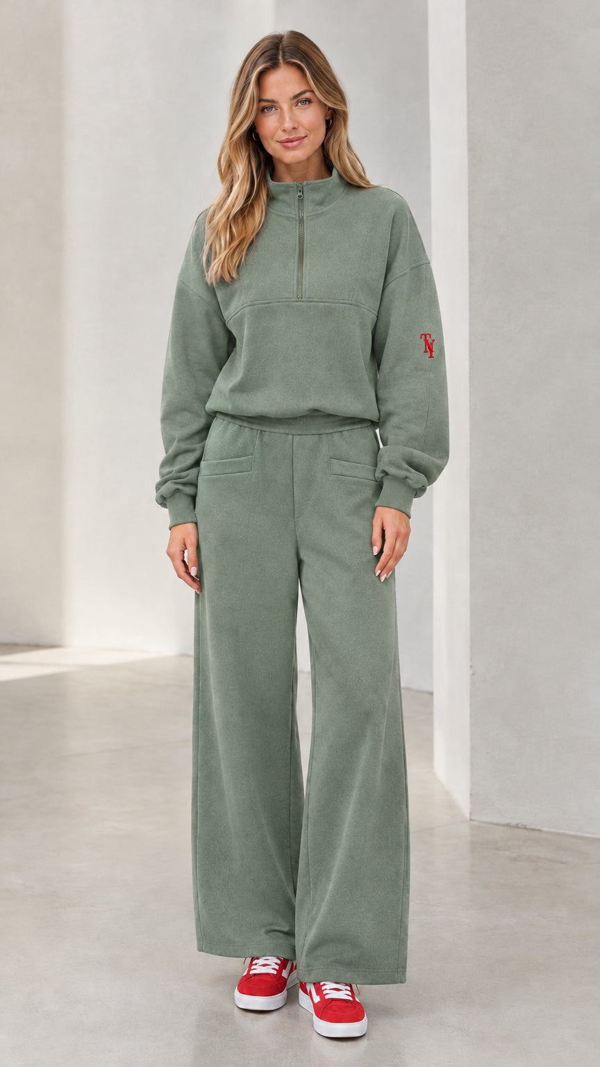 Front view of woman wearing sage green half-zip pullover and wide-leg lounge set