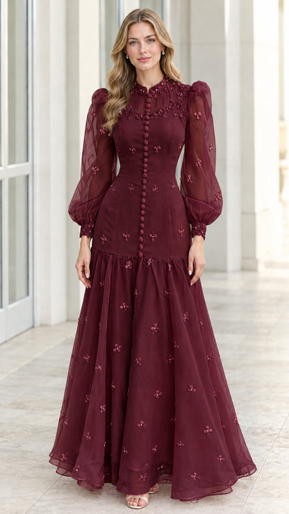 Front view of burgundy red long sleeve floral embroidered evening gown